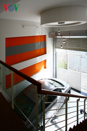 Những điểm nhấn nóng là cách trang trí nội thất nhằm đem lại sự ấn tượng. Đó là việc sử dụng các màu nóng như màu cam, màu đỏ cho một số khu vực trong không gian ngôi nhà tạo thành những điểm nhấn nóng. Ảnh: Điểm nhấn ở khoảng thông tầng ngay cửa vào, làm mảng tường lớn bớt đơn điệu.  