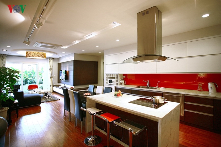 Có rất nhiều chất liệu cho màu sắc nóng như sơn tường, sơn gỗ, kính, giấy dán tường... Ảnh: Mảng nhấn bếp giữa tủ trên và tủ dưới bằng kính màu.