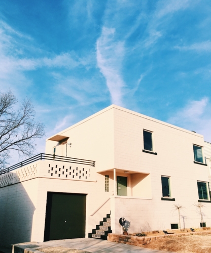 Nhìn từ bên ngoài, căn hộ là sự tối giản, hiện đại. Điểm nhấn là những ô cửa và bậc thềm tối màu.