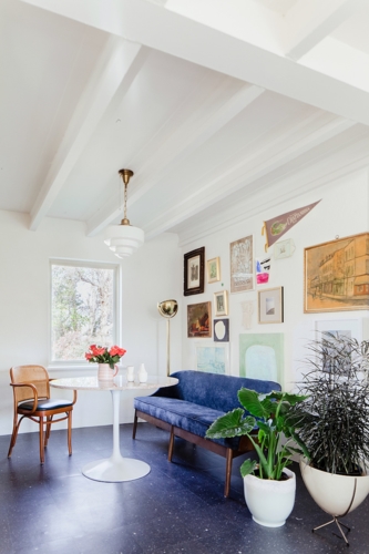 Nối tiếp phòng khách là không gian bàn trà và khu vực bếp, chủ nhà sử dụng sofa mềm và bàn tròn cùng với đèn phía trên để tạo cảm giác không quá cứng nhắc.