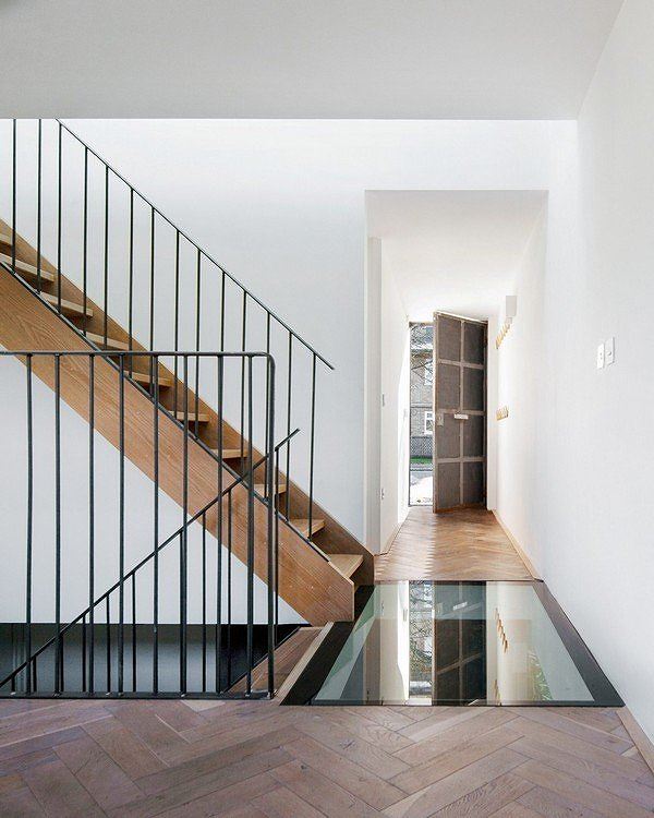 Cửa ra vào được tận dụng lại từ nhà để xe, sàn nhà làm từ gỗ tuyết tùng có cấu trúc dạng xương cá, cầu thang bằng gỗ màu sáng đem lại cảm giác ấm cúng cho ngôi nhà. Một phần sàn nhà làm bằng kính giúp cung cấp ánh sáng tự nhiên cho tầng hầm, và là điểm nhấn trong thiết kế.