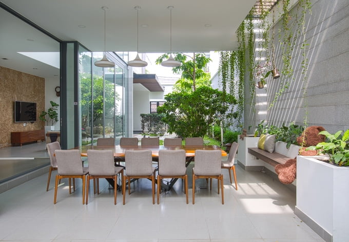 Sự kết nối không gian trong - ngoài còn được nhấn mạnh nhờ khu bàn ăn kê dưới hàng hiên, không có cửa, mở thông với sân vườn