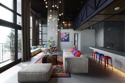 Chùm đèn hình tròn màu vàng treo trên trần nhà được chiếu thẳng xuống bộ bàn ghế sofa đã tạo nên nét lung linh huyền ảo cho căn phòng được thiết kế đơn giản. 