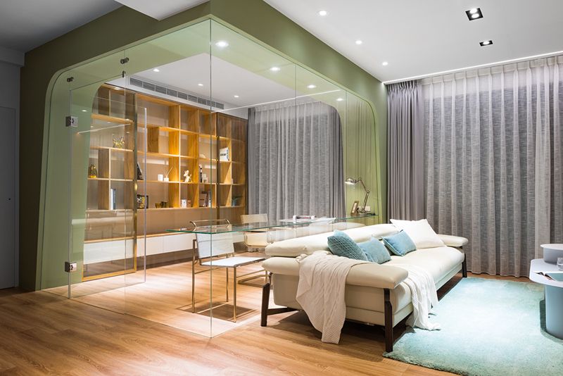 Thông qua hệ thống kính dày, một khu vực làm việc yên tĩnh được thiết lập sau ghế sofa.