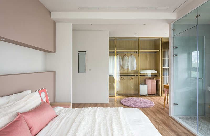 Tủ quần áo và phòng tắm cách giường ngủ thông qua một bức tường kính.